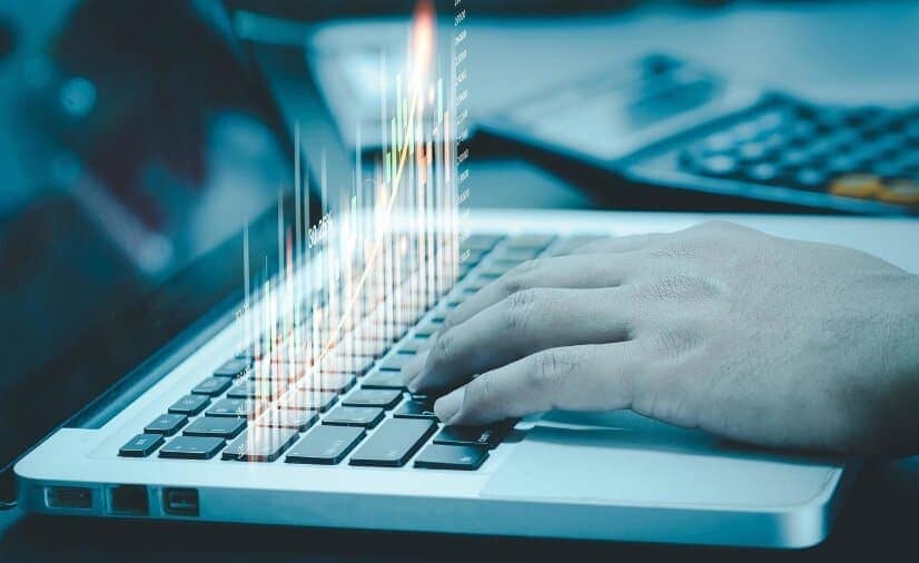 holographic trading chart on laptop keyboard