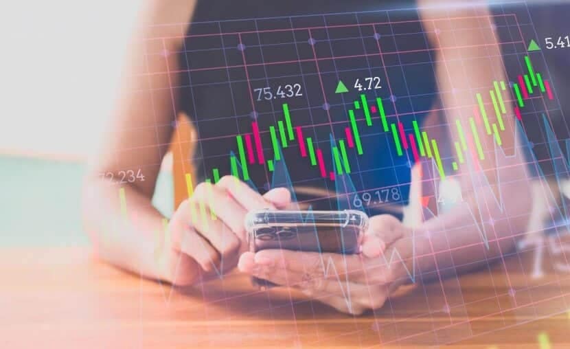 woman with phone showing virtual trading chart
